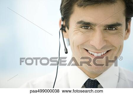 Man wearing headset, smiling at camera, portrait View Large Photo Image Stock Photo - Man wearing headset, smiling at camera, portrait. Fotosearch