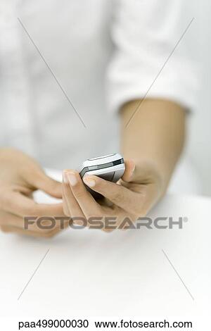 Person holding cell phone, cropped view of hands View Large Photo Image Stock Image - Person holding cell phone, cropped view of hands. Fotosearch