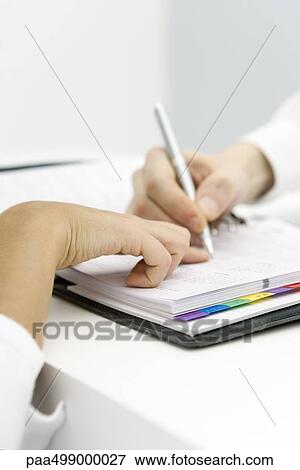 Person pointing at date in agenda, another person writing, cropped view of hands View Large Photo Image Stock Photo - Person pointing at date in agenda, another person writing, cropped view of hands. Fotosearch