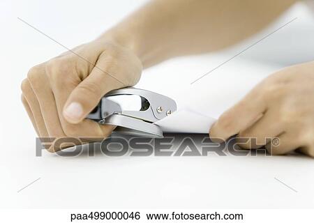 Person using hole puncher on document View Large Photo Image Stock Photograph - Person using hole puncher on document. Fotosearch