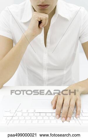 Woman in front of keyboard, hand under chin, cropped view View Large Photo Image Stock Image - Woman in front of keyboard, hand under chin, cropped view. Fotosearch