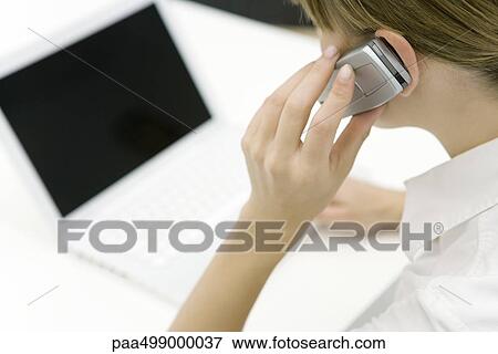 Woman using cell phone and laptop computer, cropped view View Large Photo Image Stock Photo - Woman using cell phone and laptop computer, cropped view. Fotosearch