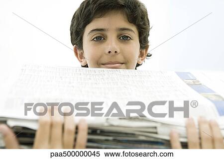 Boy holding tall stack of newspapers, smiling at camera View Large Photo Image Stock Photography - Boy holding tall stack of newspapers, smiling at camera. Fotosearch