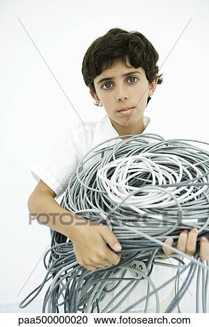 Boy holding tangled electrical cords, looking at camera View Large Photo Image Stock Image - Boy holding tangled electrical cords, looking at camera. Fotosearch