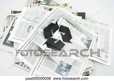 Stock Photo - Pile of newspapers spray painted with recycling symbol. Fotosearch