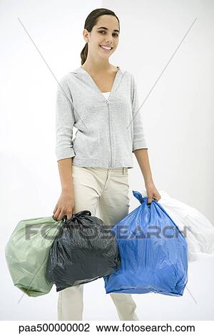 Teen girl carrying several garbage bags, smiling at camera View Large Photo Image Stock Image - Teen girl carrying several garbage bags, smiling at camera. Fotosearch