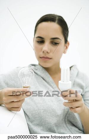 Teen girl holding two kinds of light bulb, looking down View Large Photo Image Stock Photography - Teen girl holding two kinds of light bulb, looking down. Fotosearch