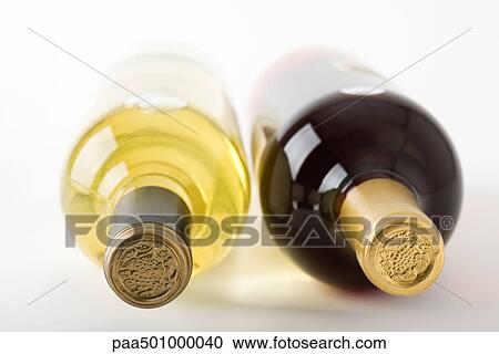 Stock Image - Bottles of red and white wine lying on their sides, close-up. Fotosearch