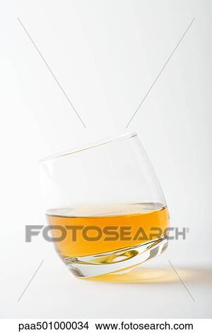 Picture - Glass of whiskey tipping, close-up. Fotosearch