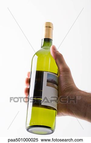 Hand holding up bottle of white wine View Large Photo Image Stock Photography - Hand holding up bottle of white wine. Fotosearch
