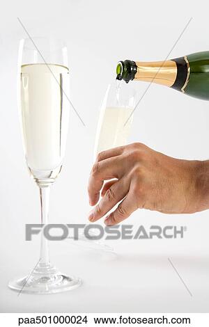 Hand pouring champagne into glasses, close-up View Large Photo Image Picture - Hand pouring champagne into glasses, close-up. Fotosearch