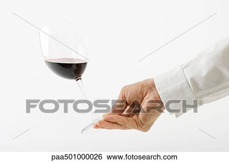 Hand tipping glass of red wine View Large Photo Image Stock Photograph - Hand tipping glass of red wine. Fotosearch