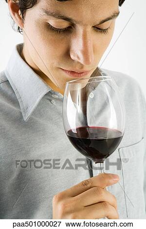 Man examining glass of red wine, close-up View Large Photo Image Stock Photo - Man examining glass of red wine, close-up. Fotosearch