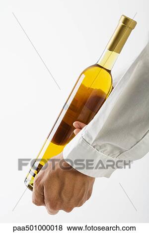 Stock Photo - Man showing bottle of white wine, cropped view. Fotosearch