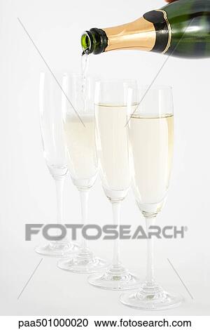 Stock Image - Pouring champagne into glasses, close-up. Fotosearch