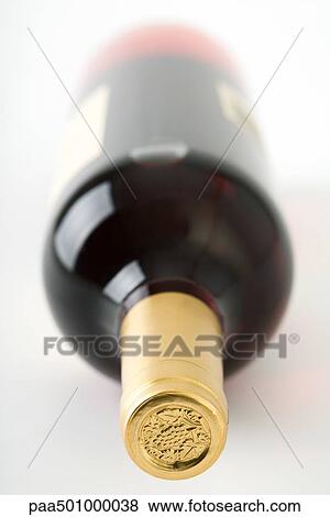 Stock Photo - Wine bottle lying on its side, focus on bottle seal. Fotosearch