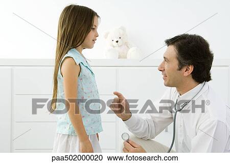 Doctor crouching, explaining something to girl, side view View Large Photo Image Stock Image - Doctor crouching, explaining something to girl, side view. Fotosearch