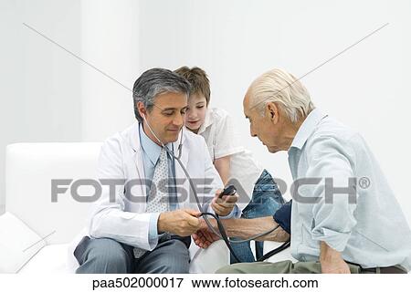 Doctor measuring senior man's blood pressure, boy watching View Large Photo Image Stock Photo - Doctor measuring senior man's blood pressure, boy watching. Fotosearch