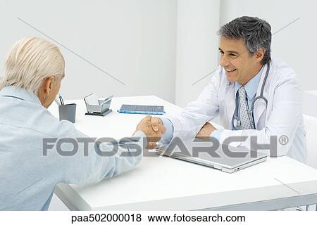 Stock Photo - Doctor shaking hands with patient. Fotosearch