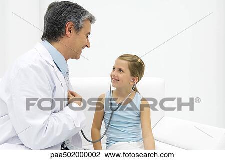 Girl listening to doctor's heart with stethoscope, smiling View Large Photo Image Stock Image - Girl listening to doctor's heart with stethoscope, smiling. Fotosearch