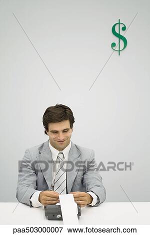 Accountant using adding machine, smiling, dollar sign on wall behind him View Large Photo Image Stock Photo - Accountant using adding machine, smiling, dollar sign on wall behind him. Fotosearch