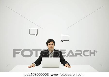 Businessman sitting with laptop computer, blank word bubbles on wall behind him View Large Photo Image Stock Image - Businessman sitting with laptop computer, blank word bubbles on wall behind him. Fotosearch