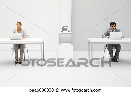 Colleagues in office using laptop computers, printer between them with graphic of document View Large Photo Image Stock Image - Colleagues in office using laptop computers, printer between them with graphic of document. Fotosearch
