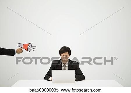 Stock Photography - Hand aiming megaphone at young professional using laptop. Fotosearch