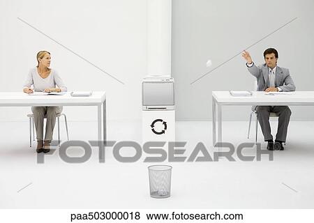 Male office worker throwing paper ball into trash can, female colleague watching View Large Photo Image Stock Photo - Male office worker throwing paper ball into trash can, female colleague watching. Fotosearch