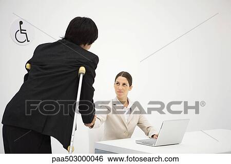Professional woman shaking hands with man on crutches View Large Photo Image Stock Photograph - Professional woman shaking hands with man on crutches. Fotosearch