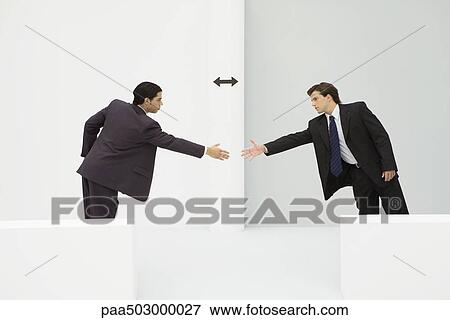 Two businessmen reaching to shake hands, arrow between them View Large Photo Image Stock Photo - Two businessmen reaching to shake hands, arrow between them. Fotosearch