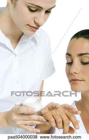 Beautician applying moisturizer to woman's hand View Large Photo Image Stock Photo - Beautician applying moisturizer to woman's hand. Fotosearch