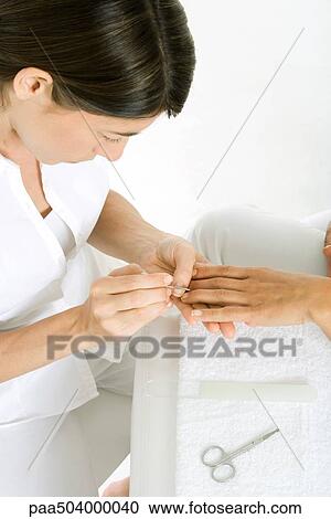 Beautician giving a manicure, cropped view of woman's hand, high angle view View Large Photo Image Stock Image - Beautician giving a manicure, cropped view of woman's hand, high angle view. Fotosearch
