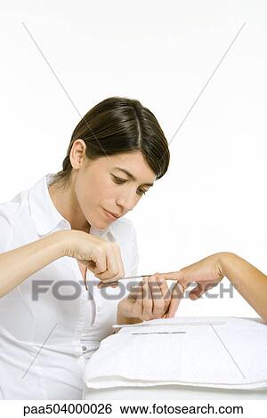 Beautician trimming a woman's nails with scissors, cropped view of hand View Large Photo Image Stock Photograph - Beautician trimming a woman's nails with scissors, cropped view of hand. Fotosearch