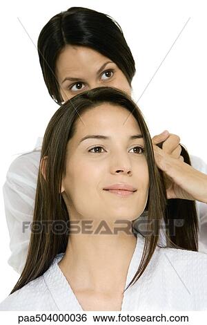 Hair stylist fixing woman's hair View Large Photo Image Stock Photograph - Hair stylist fixing woman's hair. Fotosearch