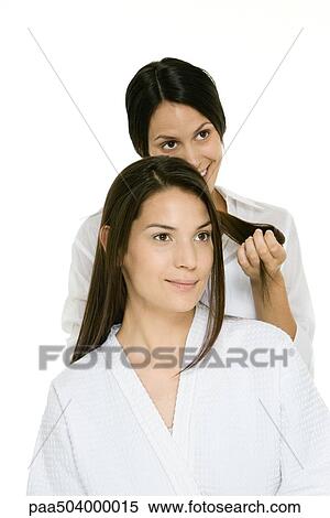 Hair stylist holding strands of a woman's hair, woman looking away and smiling View Large Photo Image Stock Photography - Hair stylist holding strands of a woman's hair, woman looking away and smiling. Fotosearch