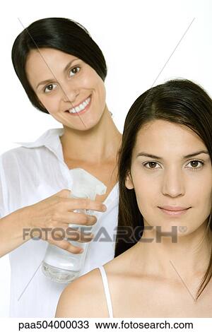 Hair stylist spraying woman's hair, both smiling at camera View Large Photo Image Stock Image - Hair stylist spraying woman's hair, both smiling at camera. Fotosearch