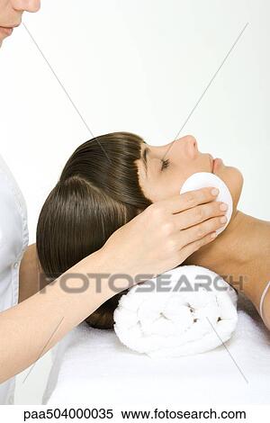 Stock Photography - Woman having her make-up removed, using towel as a pillow, cropped view. Fotosearch