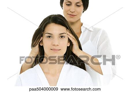 Stock Photo - Woman receiving head massage, looking at camera. Fotosearch