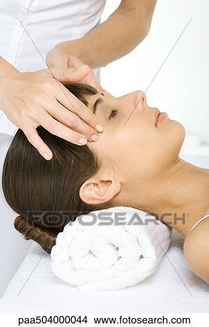 Woman receiving head massage, lying down with her eyes closed, cropped view View Large Photo Image Picture - Woman receiving head massage, lying down with her eyes closed, cropped view. Fotosearch