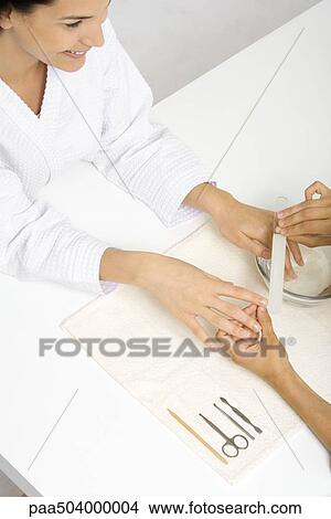 Picture - Woman receiving manicure, cropped view from directly above. Fotosearch