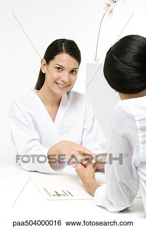 Woman receiving manicure, smiling at camera View Large Photo Image Stock Photograph - Woman receiving manicure, smiling at camera. Fotosearch