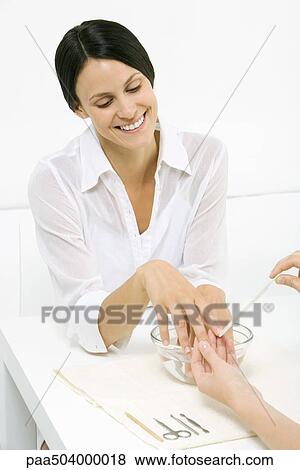 Woman soaking her fingers in bowl of water, receiving a manicure View Large Photo Image Stock Photo - Woman soaking her fingers in bowl of water, receiving a manicure. Fotosearch