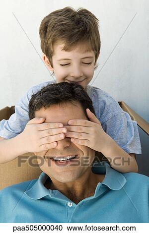Boy with hands over his father's eyes, both smiling, boy's eyes closed View Large Photo Image Stock Image - Boy with hands over his father's eyes, both smiling, boy's eyes closed. Fotosearch