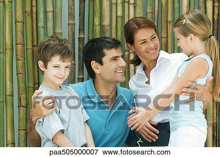 Family smiling at each other in front of bamboo, group portrait, boy looking at camera View Large Photo Image Stock Photo - Family smiling at each other in front of bamboo, group portrait, boy looking at camera. Fotosearch