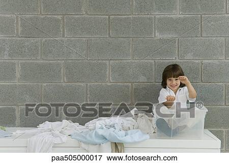 Little boy sitting in plastic storage container, laundry strewn beside him, pretending to drive View Large Photo Image Stock Photo - Little boy sitting in plastic storage container, laundry strewn beside him, pretending to drive. Fotosearch