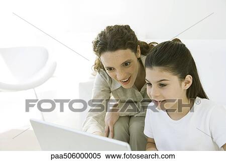 Girl using laptop, young woman looking over her shoulder with interest View Large Photo Image Stock Photography - Girl using laptop, young woman looking over her shoulder with interest. Fotosearch
