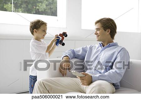 Little boy showing his father a toy truck, man holding remote control View Large Photo Image Stock Image - Little boy showing his father a toy truck, man holding remote control. Fotosearch