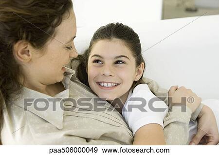Mother and daughter embracing, smiling at each other, close-up View Large Photo Image Stock Photo - Mother and daughter embracing, smiling at each other, close-up. Fotosearch