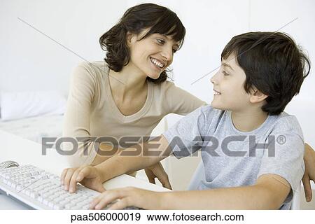 Mother and son sitting and smiling at each other, boy using keyboard View Large Photo Image Stock Photo - Mother and son sitting and smiling at each other, boy using keyboard. Fotosearch